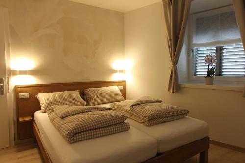 a bedroom with two beds with pillows and a window at Affittacamere Mercedes in Romallo