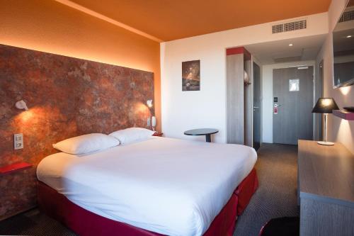 Cette chambre comprend un grand lit blanc. dans l'établissement ibis Styles Toulouse Cite Espace, à Toulouse