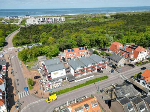 an aerial view of a town with a road and houses at Appartementencomplex Motel Texel in De Koog