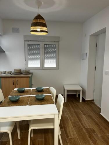 a dining room with a table and chairs and a kitchen at Casita de campo in Albacete