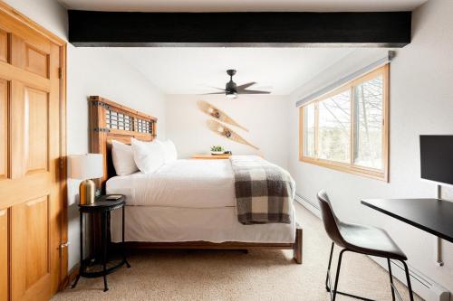 a bedroom with a bed and a desk and a window at Mod MTN Must - Steps from Shuttle - Silverthorne in Silverthorne