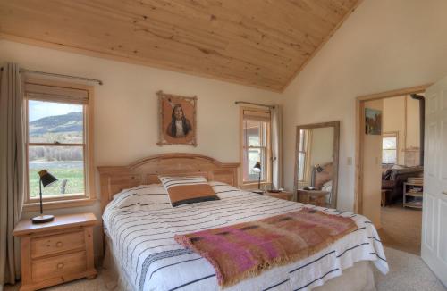 um quarto com uma cama grande e 2 janelas em River Oasis em Creede
