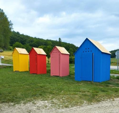 a group of seven coloredsheds sitting in a field at L'édredon de Joséphine in Montcuq