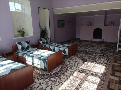 una gran sala de estar con sofás y chimenea. en Historic house, en Samarkand