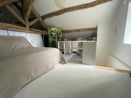 a bedroom with a bed in a room with wooden ceilings at Ecole des hautes cotes in Fussey