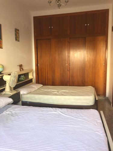 1 Schlafzimmer mit 2 Betten und einer Holzwand in der Unterkunft Planta Baja En Águilas 3 dormitorios in Águilas