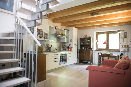 a kitchen and living room with wooden ceilings and a red couch at Apartment Bed&Bike in Arco