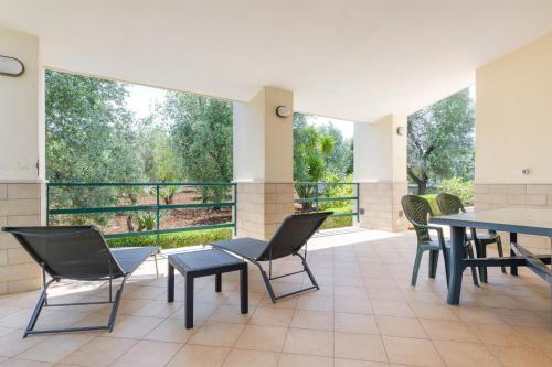 um quarto com cadeiras e mesas e uma grande janela em Villa Laura em Carovigno