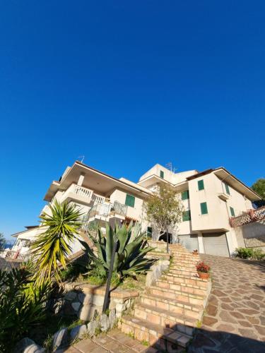 a house with stairs in front of a building at I giardini del castello in Mandatoriccio Marina