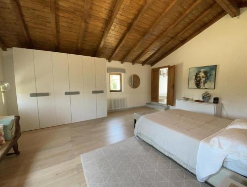 ein Schlafzimmer mit einem großen Bett und einer Holzdecke in der Unterkunft Casale del Pozzo-Villa with pool - Fosdinovo in the borgo of Pulica in Tendola