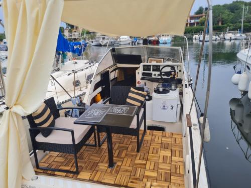 a table and chairs on a boat in the water at LUPA - La flotta di Willy Giò in Alghero