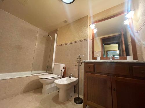 La salle de bains est pourvue de toilettes, d'un lavabo et d'un miroir. dans l'établissement L11 - Bajo con jardín en Linsoles - Villmor, à Anciles