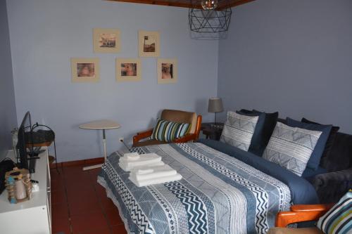 a bedroom with a bed with a blue comforter at Alojamento Local de Santa Catarina in Praia da Vitória