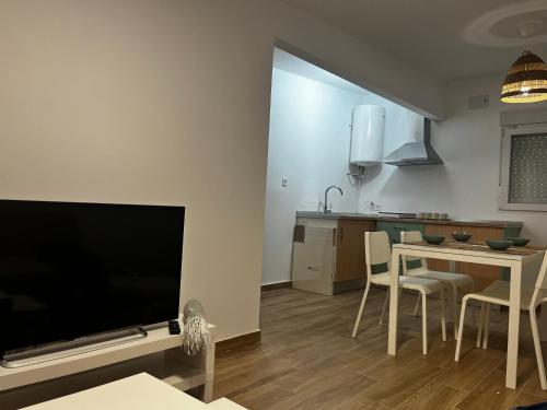 a living room with a television and a table with chairs at Casita de campo in Albacete