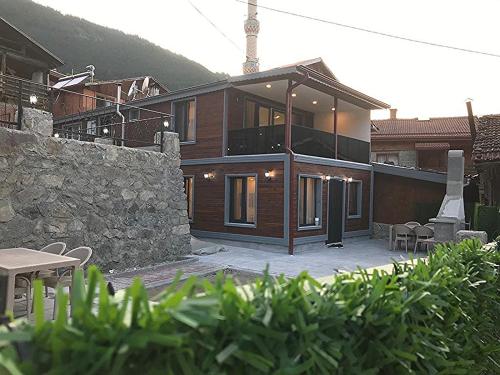 Garden House Uzungöl في أوزونغول: منزل خشبي كبير بجدار حجري