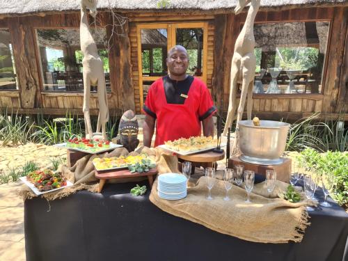 a man standing in front of a table of food at Karongwe - River Safari Lodge in Hoedspruit