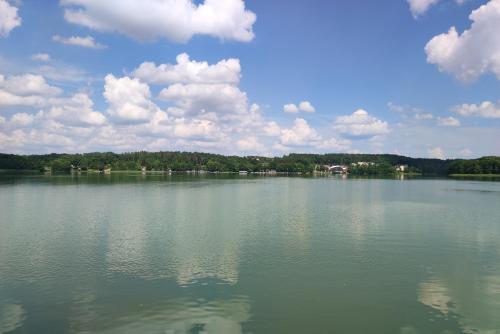a large body of water with clouds in the sky at Apartament Natura in Mrągowo