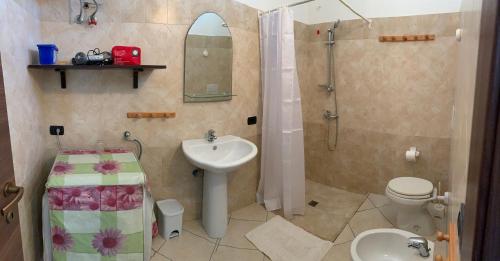 a bathroom with a sink and a shower and a toilet at CASE VACANZA ZOE - LUNA in Serrano