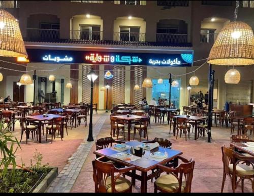 an empty restaurant with tables and chairs and lights at Aqua View north coast for Egyptians only in El Alamein