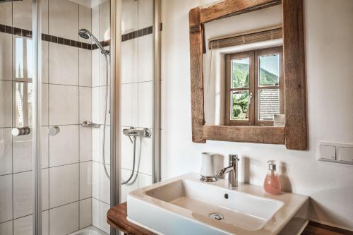 La salle de bains est pourvue d'un lavabo et d'une douche. dans l'établissement st martin chalets, à Sankt Michael im Lungau