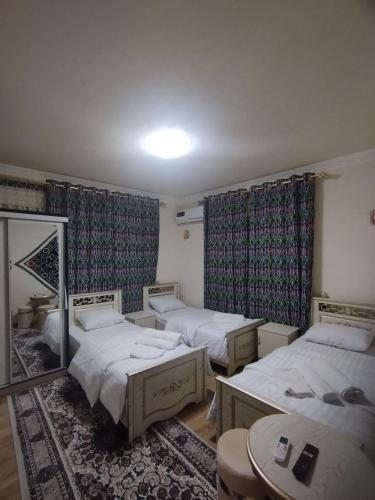 een kamer met 2 bedden en een spiegel bij Qozi Hotel in Samarkand