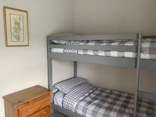 a bedroom with two bunk beds and a small bed at Tipsy Cottage Charming 2 bedroom home. in Burley in Wharfedale
