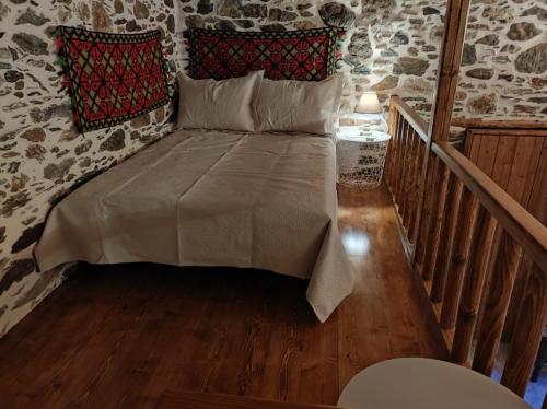 a bedroom with a bed in a room with a staircase at Πέτροκτιστο Σπίτι. Stone House in Ayía Kiriakí