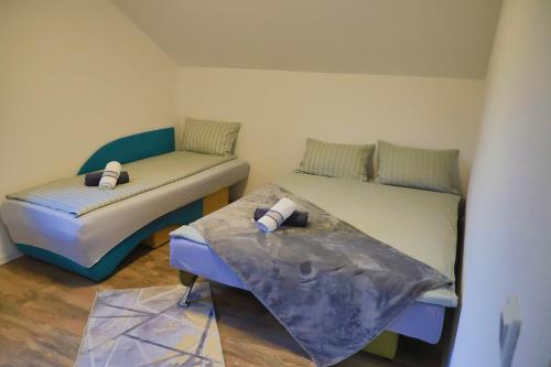 a room with two beds and a table in it at Apartman Enjoy in Bihać