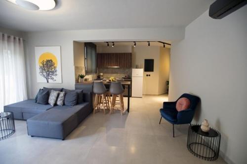 a living room with a blue couch and a kitchen at Animus Premium apt in Nafplio