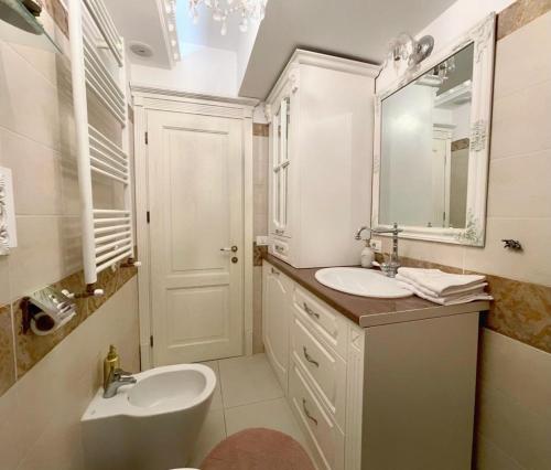 a white bathroom with a sink and a mirror at Lux apartament in Focşani
