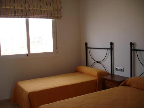 zwei Betten in einem Zimmer mit zwei Fenstern in der Unterkunft SALINAS DE VERA APARTAMENTO in Vera