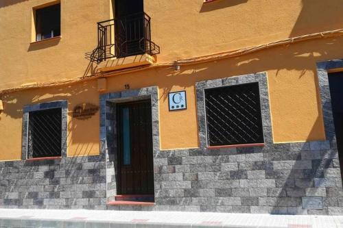 un edificio con un reloj al costado. en Casa Rural Los Mayorales, en Esparragalejo
