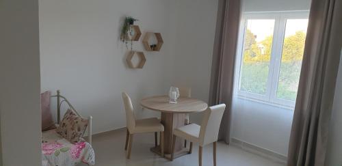 a table and chairs in a room with a window at Apartments Aurora in Jezera