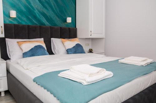a bedroom with a large bed with towels on it at Apartament Zeuss Neptun in Neptun