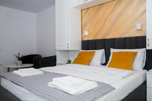 a bedroom with a large bed with two towels on it at Apartament Zeuss Neptun in Neptun