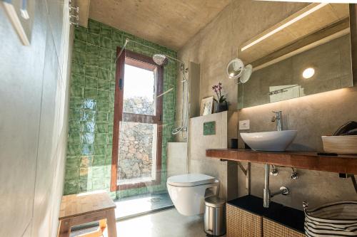 La salle de bains est pourvue de toilettes, d'un lavabo et d'une fenêtre. dans l'établissement La Candia y el Mar, à Valverde