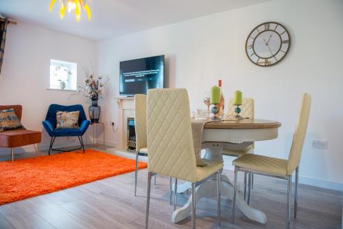 sala de estar con mesa, sillas y reloj en Bomaquarters COSY AND LUXURIOUS 2 BED VILLIERS HOUSE en Coventry