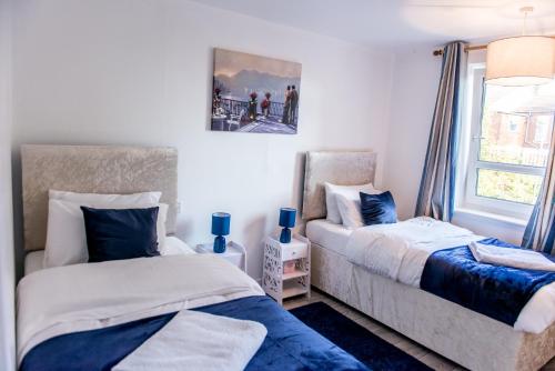 um quarto com 2 camas e uma janela em Bomaquarters COSY AND LUXURIOUS 2 BED VILLIERS HOUSE em Coventry