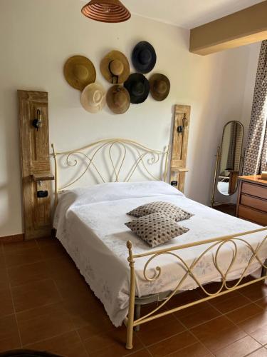 - une chambre avec un lit avec des chapeaux sur le mur dans l'établissement Casa De Crescenzo con piscina, à Bellona