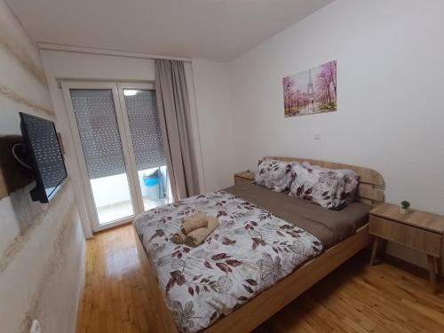 a small bedroom with a bed and a window at Finesi apartments 3 in Ohrid