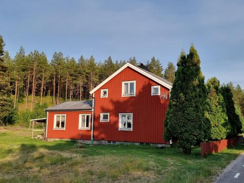 a red house in the middle of a field at Gamla Kooperativa in Ekshärad