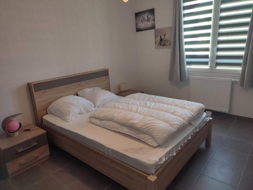 un lit avec des draps blancs et des oreillers dans une chambre dans l'établissement Sète : charmant T3 entre l'étang et les plages, à Sète