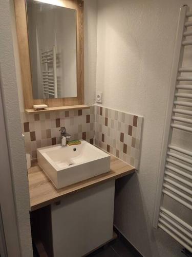 une salle de bain avec un lavabo blanc et un miroir dans l'établissement Sète : charmant T3 entre l'étang et les plages, à Sète