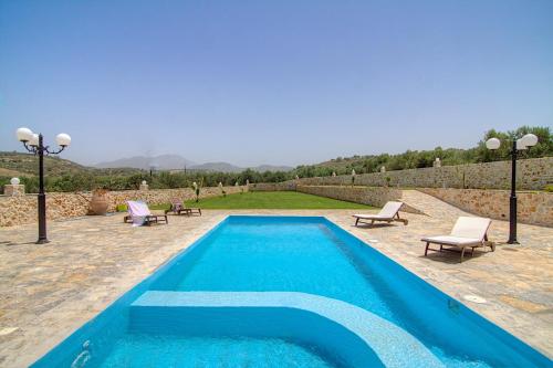 RoumelíにあるNestor Villa, with Private Pool & Absolute Privacyのラウンジチェア2脚とプール1つが備わるスイミングプールを併設しています。