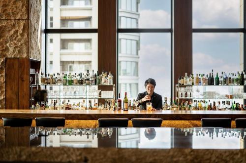 a man sitting at a bar with a drink at InterContinental Hotel Osaka by IHG in Osaka