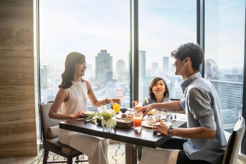 a group of people sitting at a table in a restaurant at InterContinental Hotel Osaka by IHG in Osaka