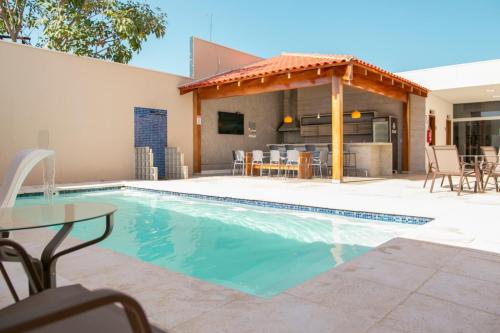 a swimming pool with a table and a house at MAPER MARDAN in Parauapebas