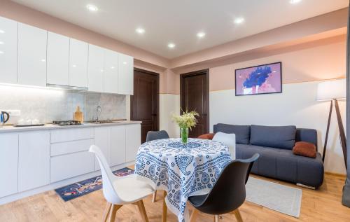 Devdaraki Apartments في كازباجي: مطبخ وغرفة معيشة مع طاولة وكراسي