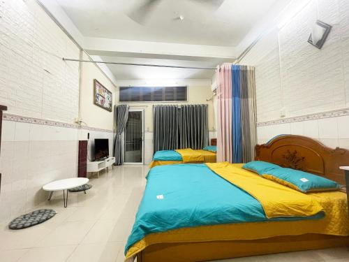 1 dormitorio con 2 camas con sábanas amarillas y azules en DucTaigallery's Apt&Center in Saigon, en Ho Chi Minh