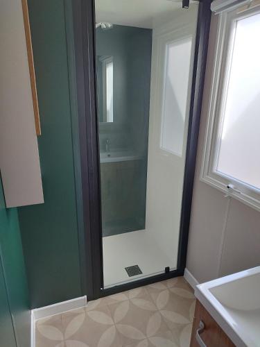 une salle de bain avec une douche en verre et un lavabo dans l'établissement Mobil home 6/8personnes, à Sérignan